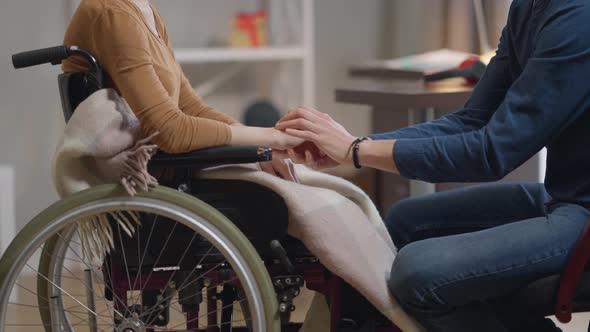 Side View Unrecognizable Caucasian Man Taking Hands of Disabled Woman Endorsing Paralyzed Lady