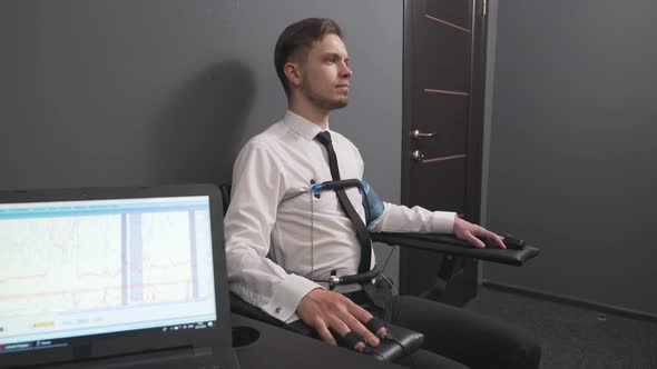 Serious Man with Pulse Electrodes Connected To Polygraph