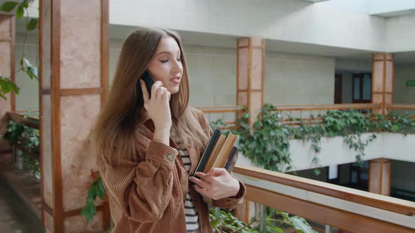 Woman Student Is Walking In Hall and Talking Phone