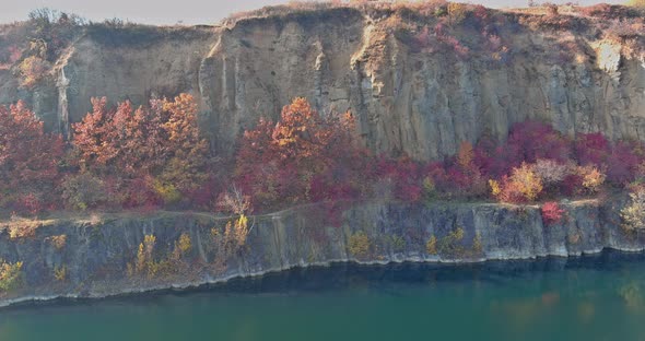 An Quarry Pond Formed During Mining Stone with Overgrown with Green Plants with Clear Turquoise