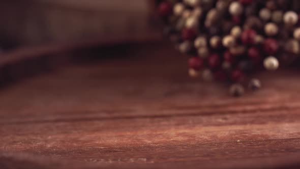 Colorful Pepper Falling on a Wooden Table