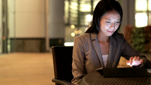 Businesswoman use of tablet computer at night 