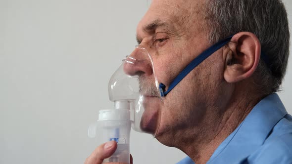 Senior Man Inhaling Through Inhaler Mask