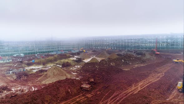 Excavation. Clearing construction site. Extending oil refinery site on foggy day
