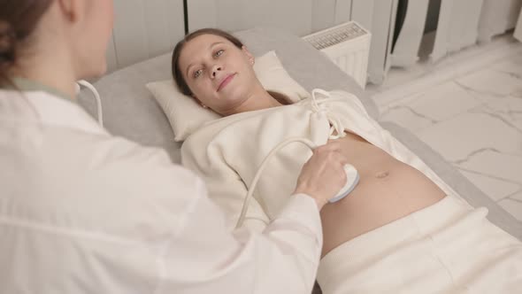 Happy Pregnant Woman Doing Ultrasound Scan of Her Baby