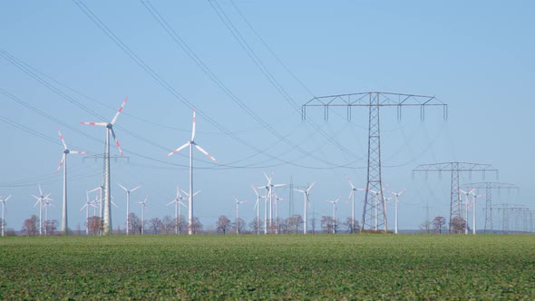 Field with lots of Windmills and Overhead Power Cable
