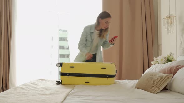 Woman Is Packing Yellow Suitcase in the Hotel Room