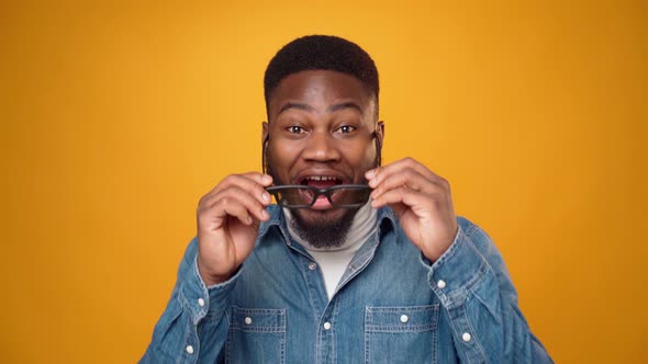 Portrait of Amazed Black Man Taking Off Black Glasses