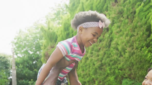 Happy african american couple with their daughter playing in garden