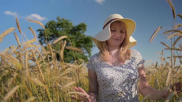 Woman in Hat Walking on Barley Field
