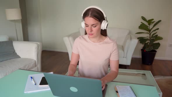 Woman Teenager in Headphone Using Laptop for Online Study From Home Office