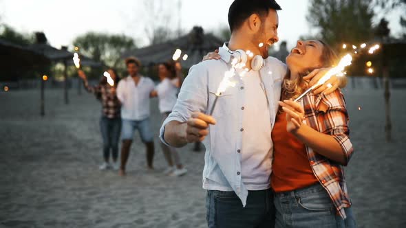 Group of Happy Friends Having Fun on Beach at Night