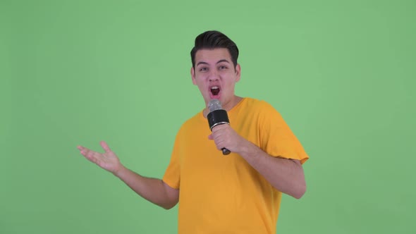 Happy Young Multi Ethnic Man Singing with Microphone