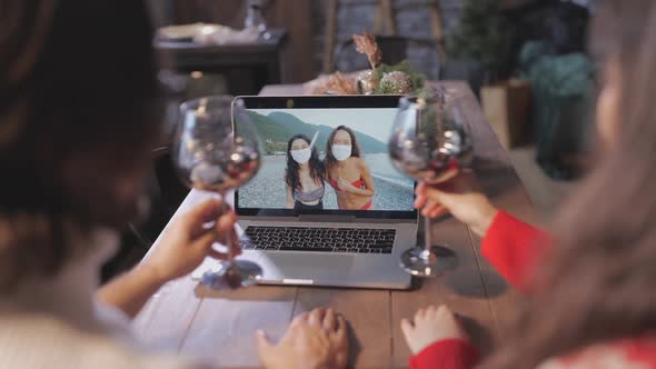 Young Couple Celebrating Xmas with Their Friends Via Video Chat on Laptop