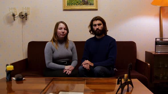 Portrait of young soviet couple watching television on the sofa