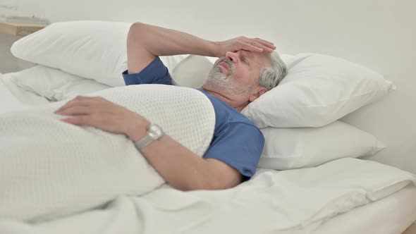 Headache, Tense Old Man With Head Pain Lying in Bed