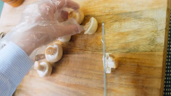 The Chef Cuts the Mushrooms in Half with a Professional Knife