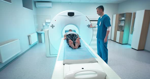 Male Doctor and Patient Finishing CT Scan