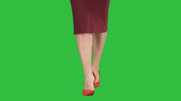 Slim legs of woman wearing high heel shoes walking on a