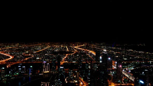 Dubai Downtown View from Skyscraper at Night with Car Traffic Moving on Roads in Time Lapse