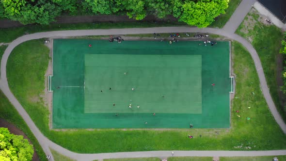 Aerial View of Men Playing Football on a Public City Soccer Field