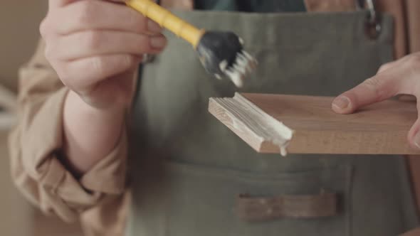 Professional Joiner Applying Glue on Plank