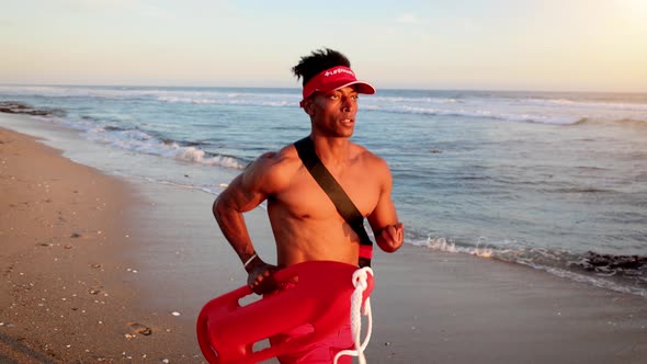 Male lifeguard running along the beach