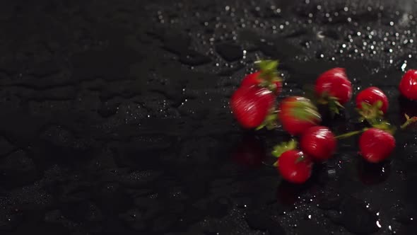 Closeup of Strawberries on a Wet Black Surface