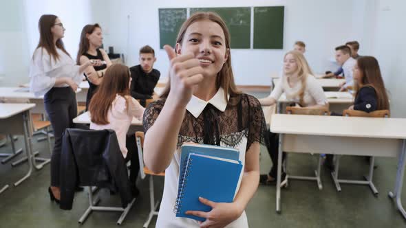 Portrait of a Young Russian Senior School Graduate Showing Success with the Help of a Finger in the