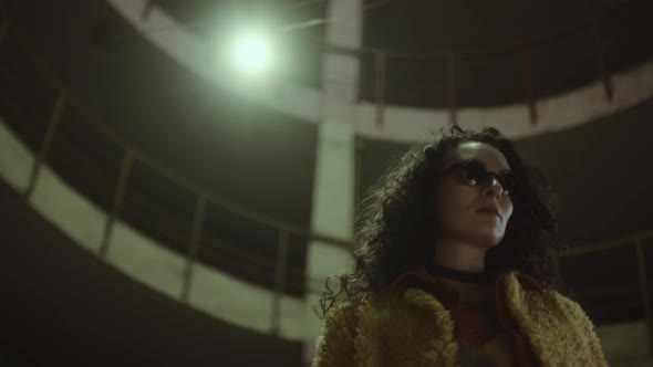 Woman in Sunglasses on Street at Night