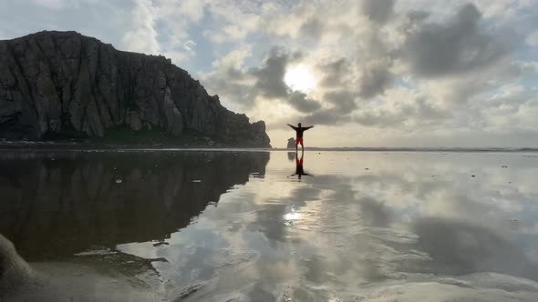 Freedom, guy walking at the beach in morro bay california, iconic morro bay rock, water reflection