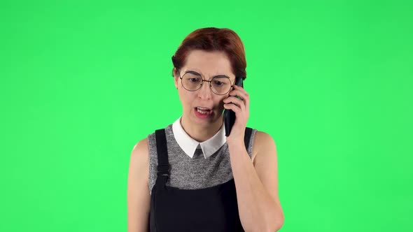 Portrait of Funny Girl in Round Glasses Is Angrily Talking for Mobile Phone, Proving Something