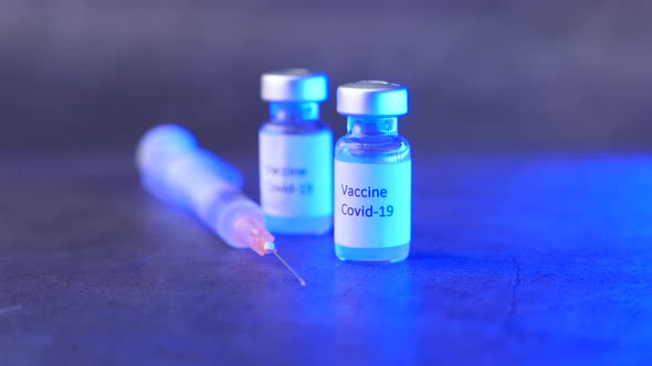 Close Up of Coronavirus Vaccine and Syringe on Black Background