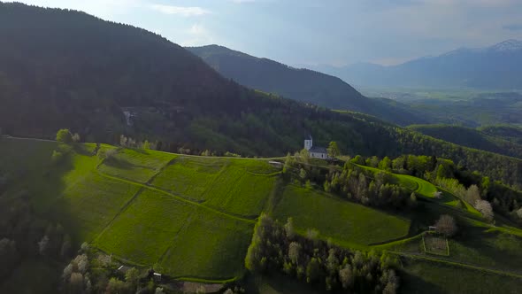 drone footage sunset at Church of St. Primus and Felician, Jamnik, Slovenia 