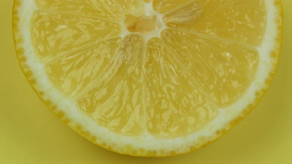 Lemon Cut In Half Rotates On a Yellow Background