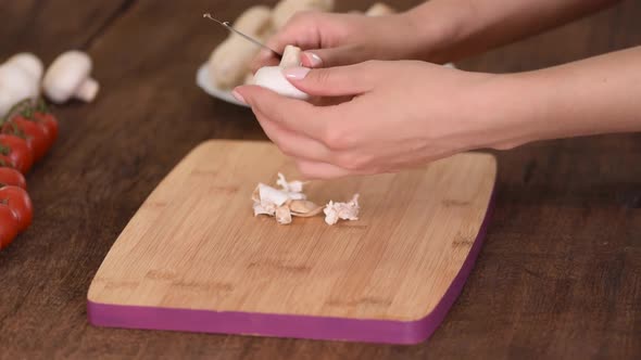  Woman is peeling off mushroom on kitchen.