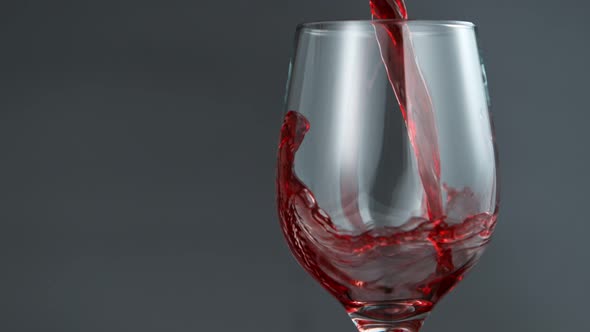 Pouring Red Wine in Super Slow Motion on Grey Background