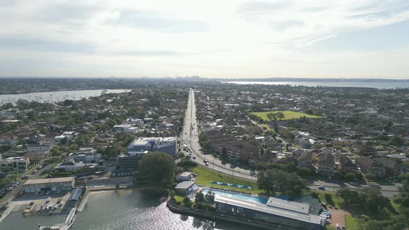 Aerial forward flying toward the dual carriageway highway between properties. Cinematic above the oc