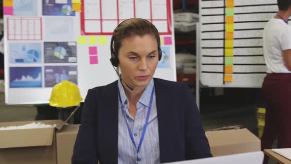 Young woman working at a desk in a warehouse 4k