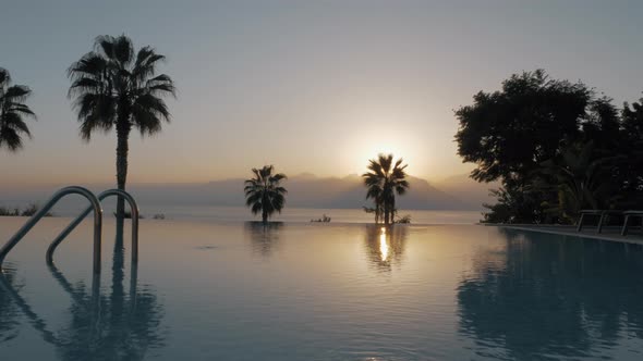 A steadicam shot of an open empty swimming pool by the sunset