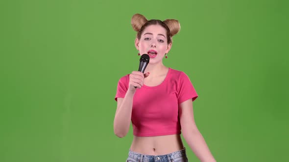 Teenager Sings Into the Microphone. Green Screen