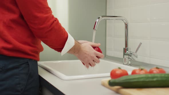 A person washes bell pepper