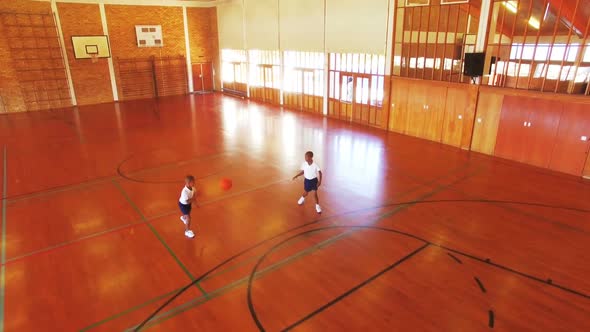 Boys playing basketball in court