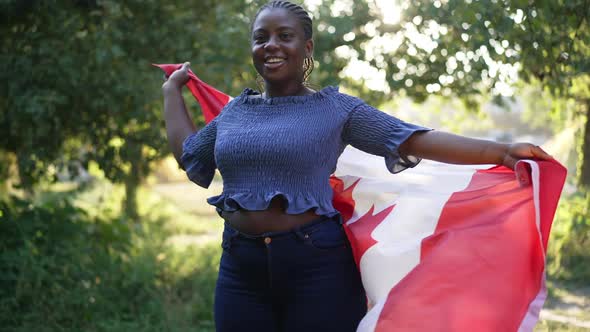 Excited Happy African American Plussize Woman Spinning with Canadian Flag in Slow Motion Smiling