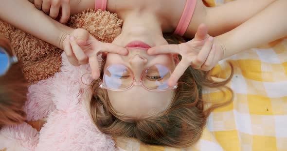 A Little Happy Girls with Glasses Rests and Sends Greetings with Her Hand