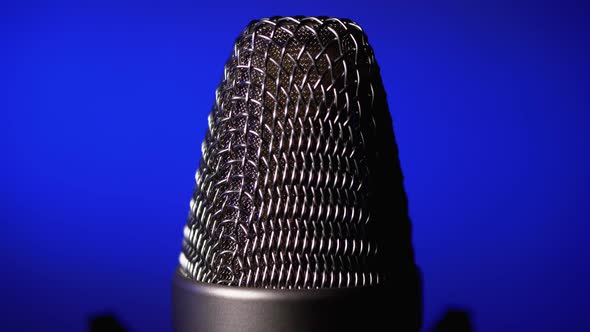 Studio Condenser Microphone Rotates on Blue Background.