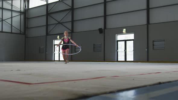 Teenage female gymnast performing at sports hall