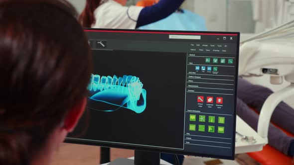 Stomatologist Nurse Looking at Digital Dental Fingerprint on Computer