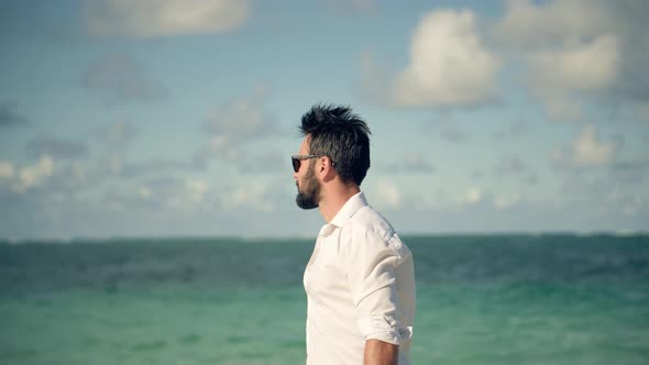 Man In White Shirt Walks Along Beach On Tropical Caribbean Hotel. Businessman Walking On Tropical.
