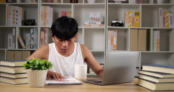 Tired man using laptop and looking document